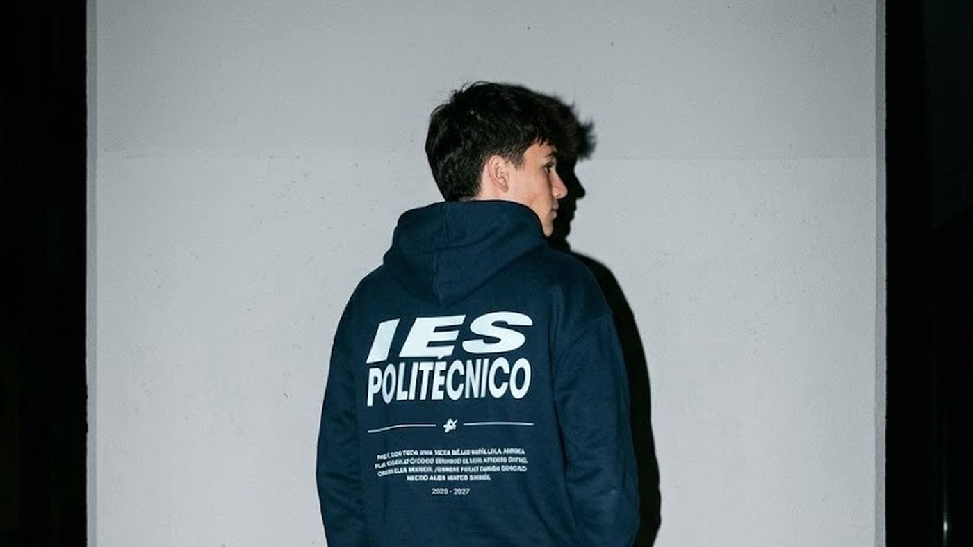 Chico de espaldas con una sudadera azul marino con IES POLITÉCNICO en grande y los nombres de la promoción debajo